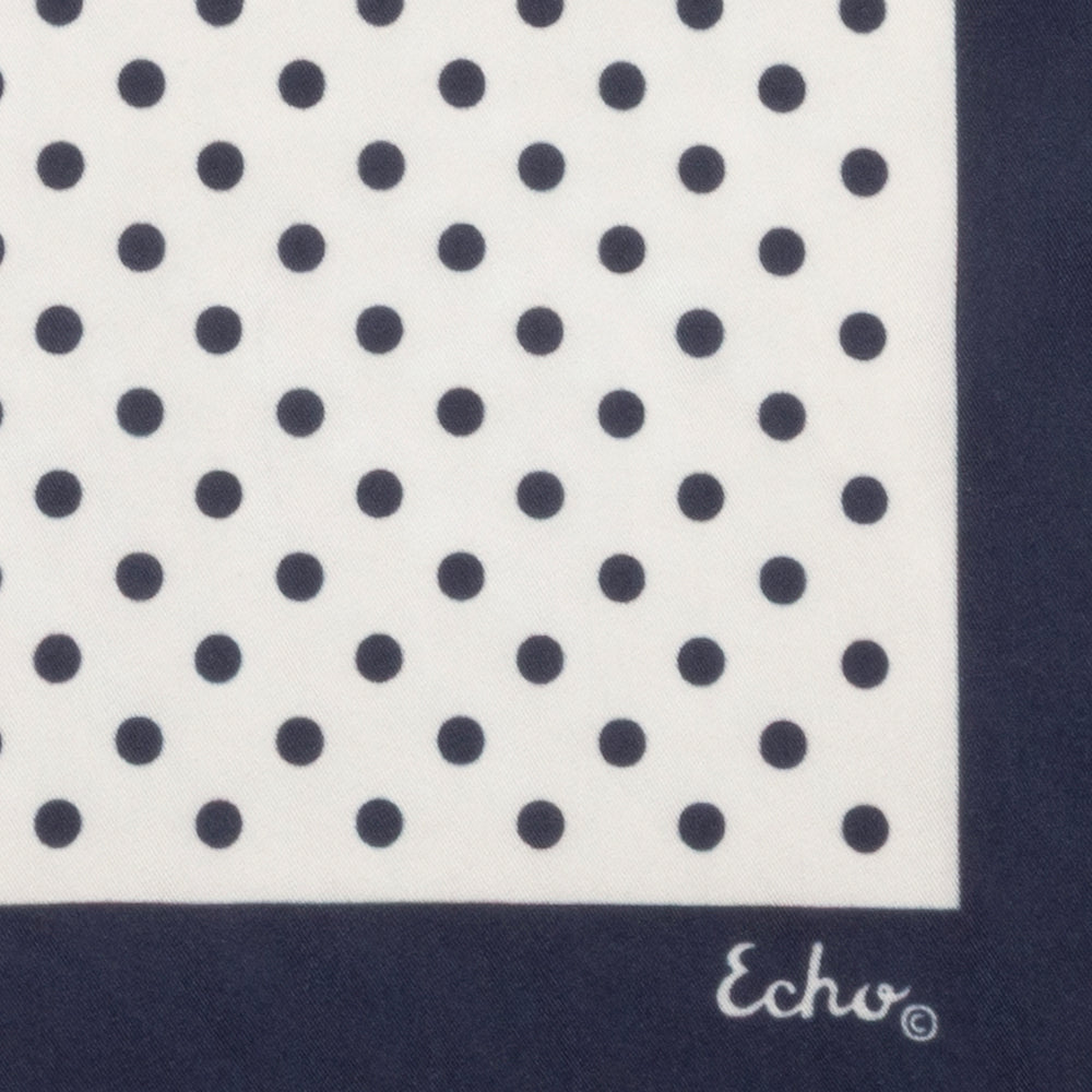 Navy blue square scarf with white polka dot pattern on a white background