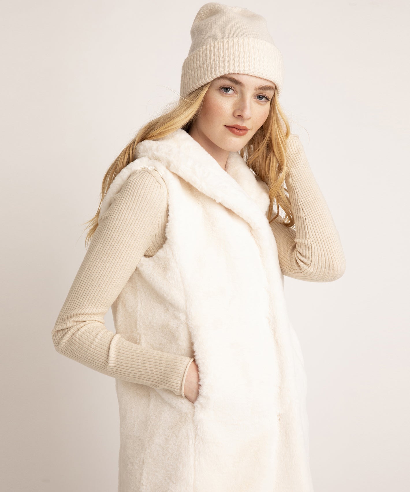 Model wearing the longline mink faux fur vest in color cream.